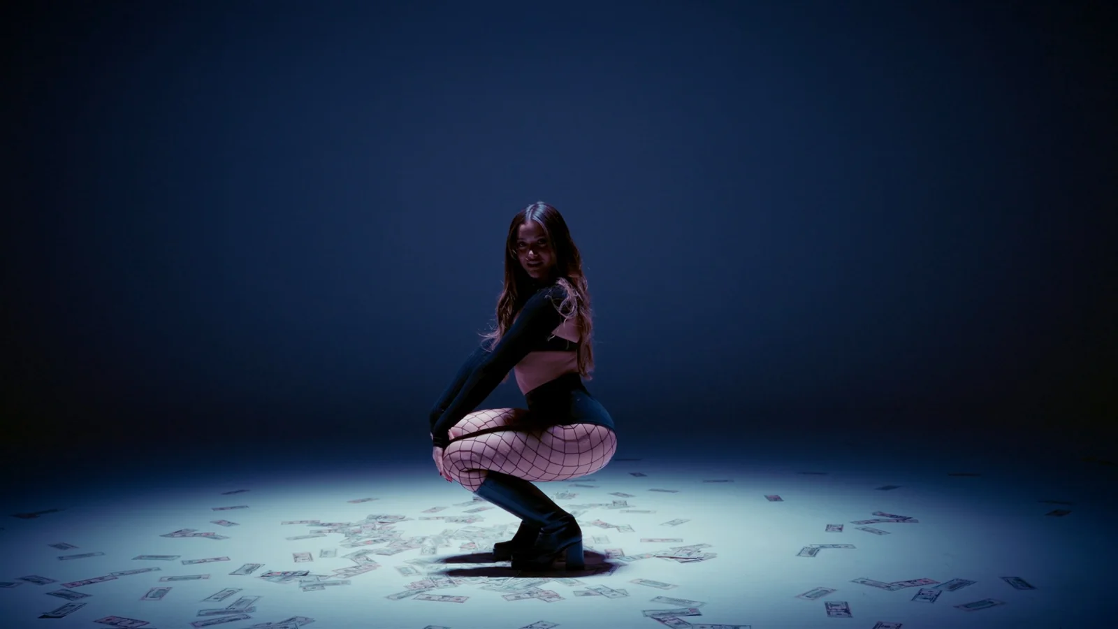 A performer in a pool of blue studio light